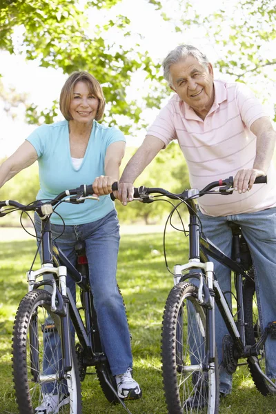 Couple aîné faisant du vélo dans le parc — Photo