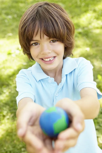 Niño sosteniendo modelo de globo en parque —  Fotos de Stock