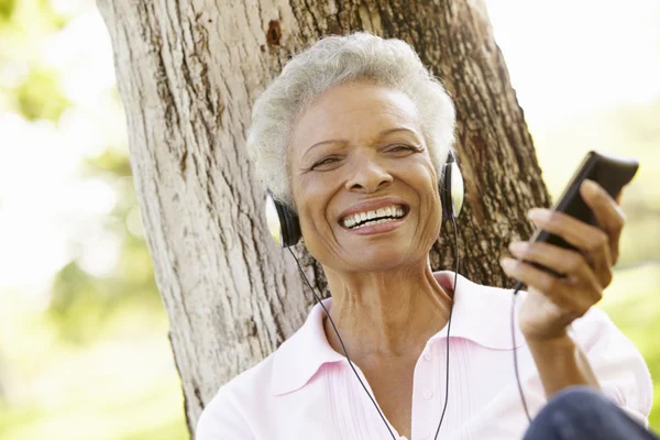 Mujer mayor en la escucha de reproductor de MP3 — Foto de Stock