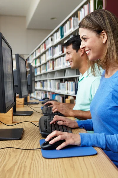 Estudiantes trabajando en computadoras en la biblioteca —  Fotos de Stock