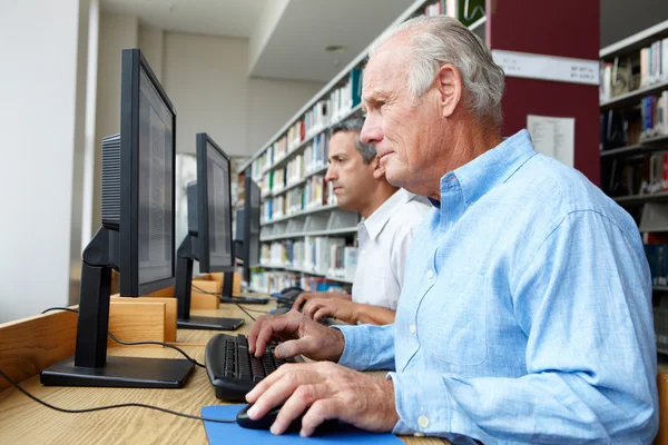 Hommes travaillant sur des ordinateurs en bibliothèque — Photo