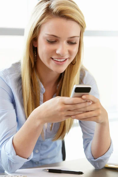 Adolescente con teléfono móvil en clase — Foto de Stock