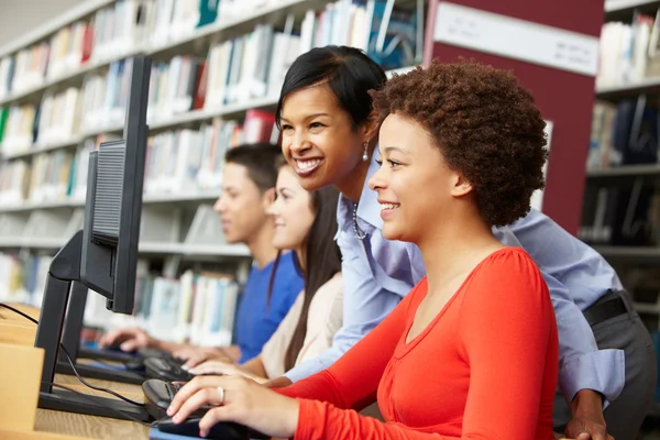 Professores e alunos que trabalham em computadores — Fotografia de Stock