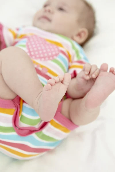 Bebê menina brincando com dedos dos pés — Fotografia de Stock