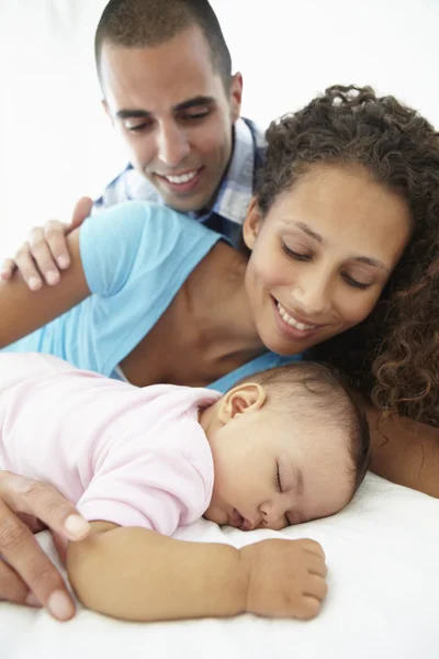 Pais com a filha do bebê adormecida em casa — Fotografia de Stock