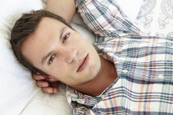 Mladý muž v posteli — Stock fotografie