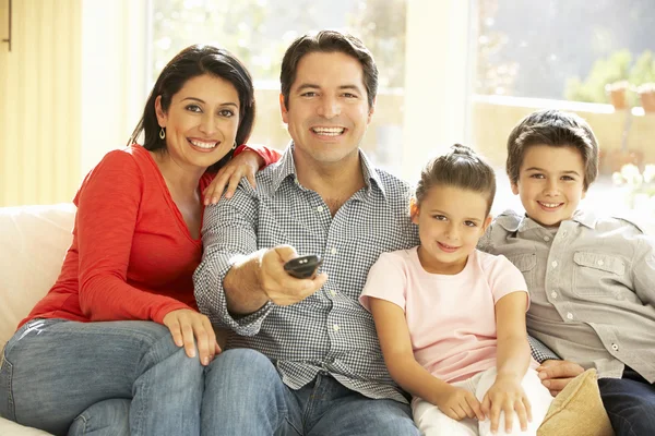 Jovem família assistindo TV em casa — Fotografia de Stock