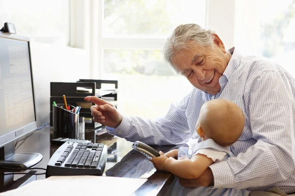 Homem sênior com bebê usando o computador — Fotografia de Stock