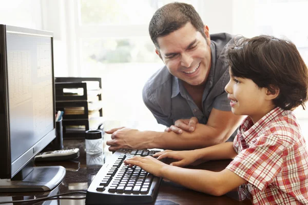 Pai e filho usando computador em casa — Fotografia de Stock