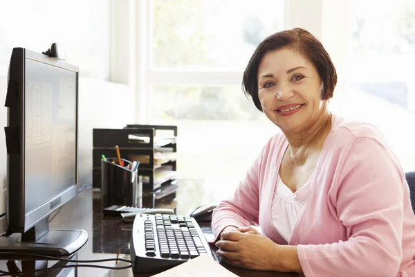 Oudere vrouw die thuis werkt — Stockfoto