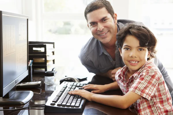 Pai e filho usando computador em casa — Fotografia de Stock