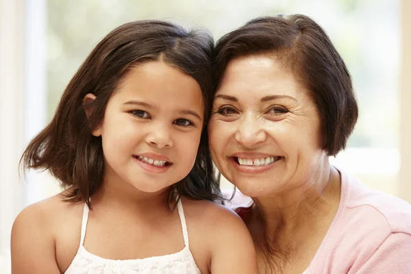 Oma en kleindochter glimlachen naar de camera — Stockfoto