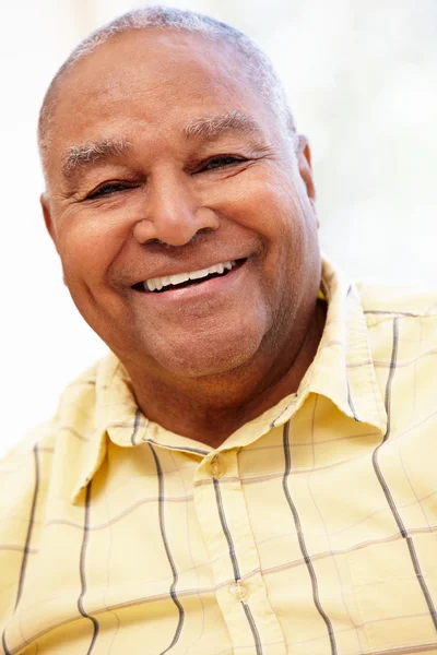 Senior man glimlachen en kijken naar camera — Stockfoto