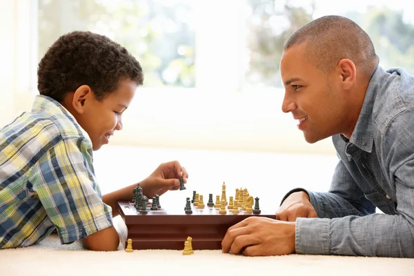 Отец играет в шахматы с сыном — стоковое фото