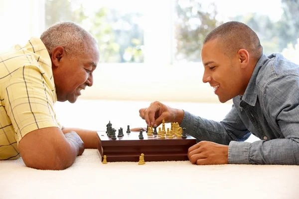 Äldre man spelar schack med son — Stockfoto