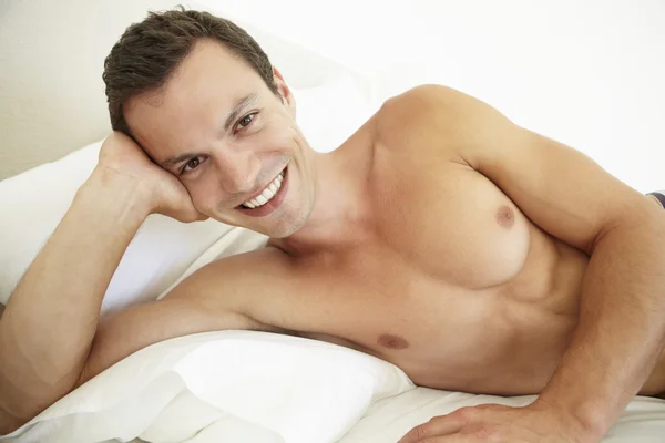 Young Man Relaxing On Bed Stock Photo