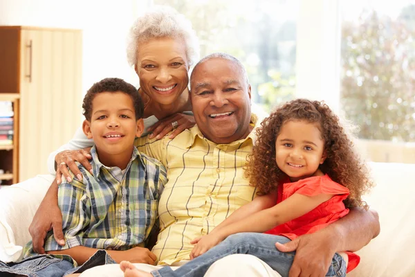 Abuelos y nietos sentados en el sofá — Foto de Stock