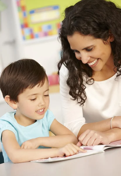 Schoolmeisje leesboek met leraar — Stockfoto