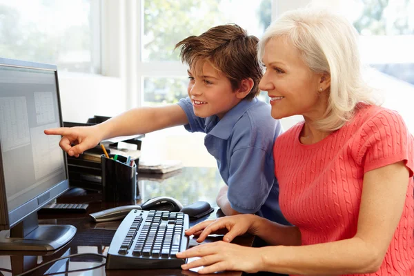 Бабушка и внук за компьютером — стоковое фото