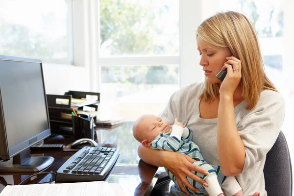 Moeder werken met baby in kantoor aan huis — Stockfoto