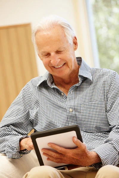 Homem idoso usando tablet em casa — Fotografia de Stock