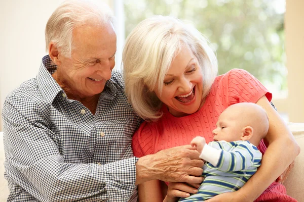 Senior couple holding baby grandson — Stockfoto