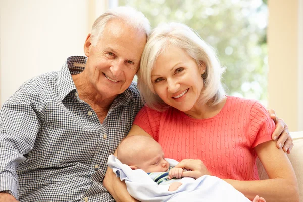 Senior couple holding baby grandson — Stock Photo, Image