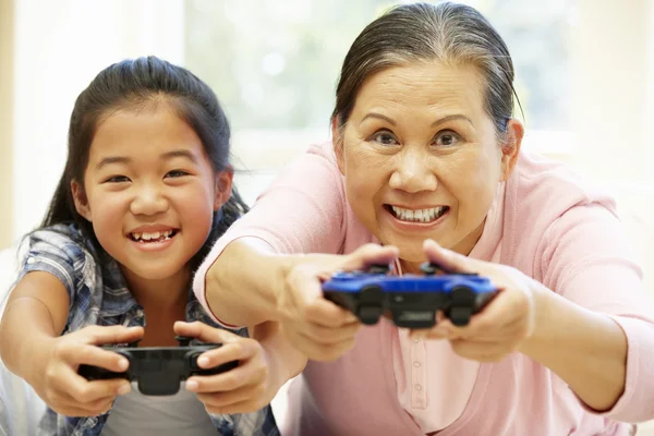 Grandmother with granddaughter playing video game — Stockfoto