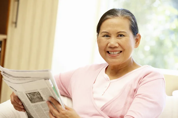 Старшая женщина читает газету — стоковое фото