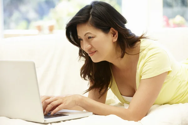 Mulher asiática usando laptop em casa — Fotografia de Stock