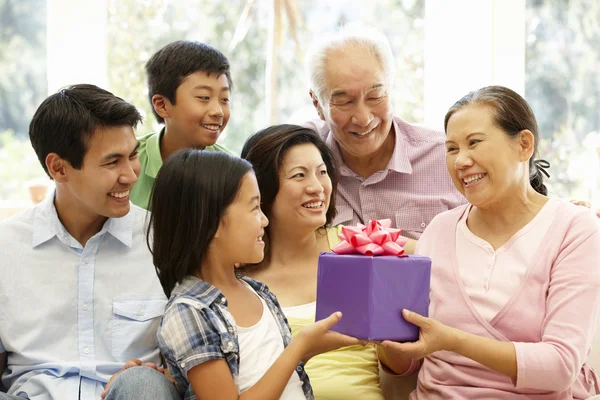 Gelukkige familie aanwezig is om hun grootmoeder — Stockfoto