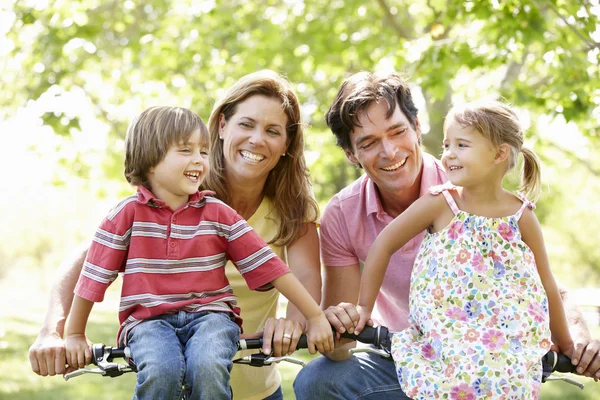 Family riding bikes in park — Stock Photo, Image