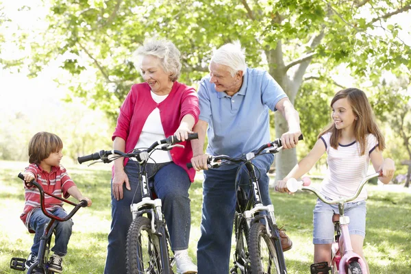 Grandparents and children riding bikes — Stock Photo, Image