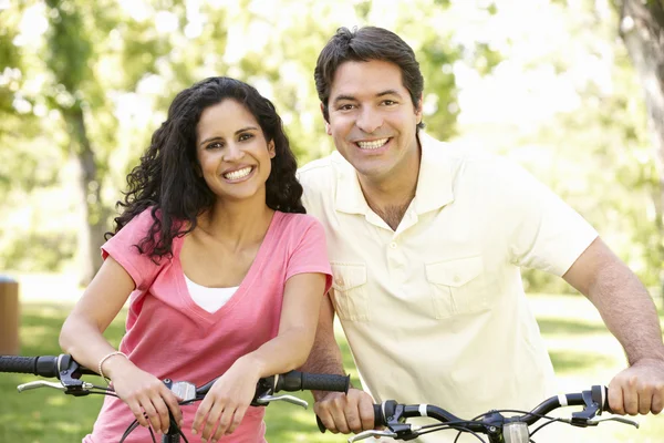 Pareja joven en bicicleta en el parque —  Fotos de Stock