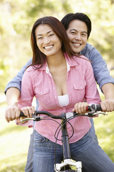 Couple both sitting on one bicycle — Stock Photo, Image