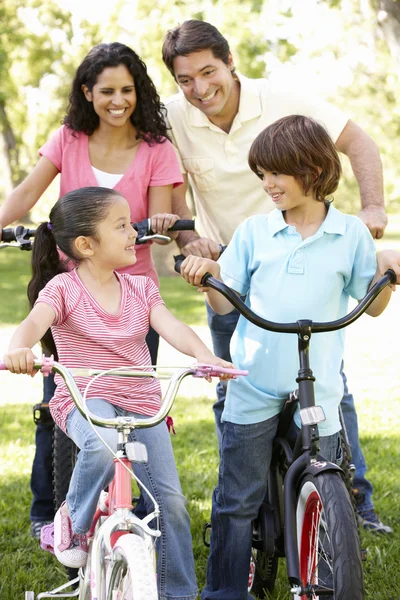 Молода сім'я, їзда на велосипеді в парку — стокове фото