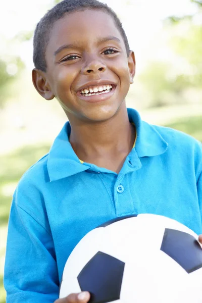 Jovem menino segurando bola de futebol — Fotografia de Stock