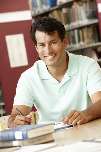 Mature student working in library — Stock Photo, Image