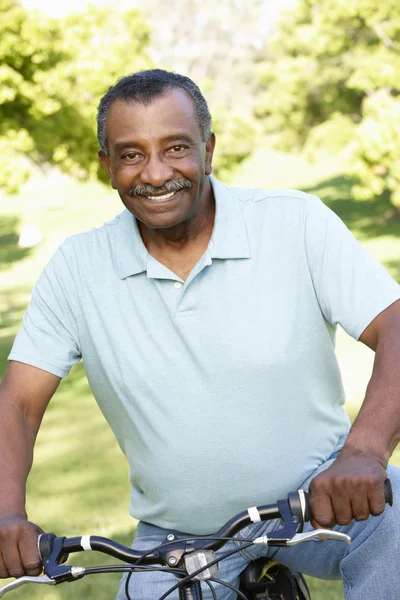 Senior man fietsen in park — Stockfoto