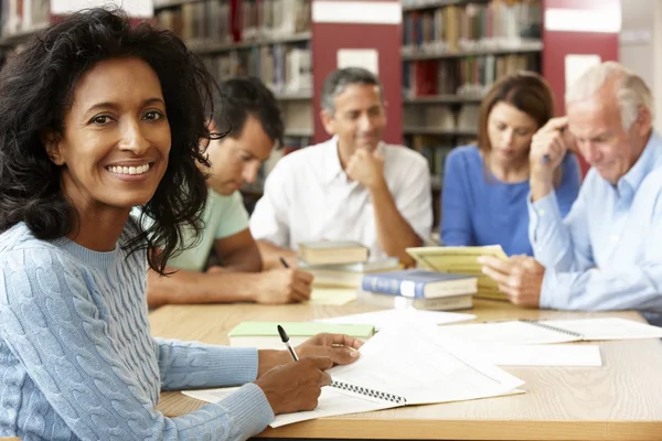 Mature students working in library — Stock Photo, Image