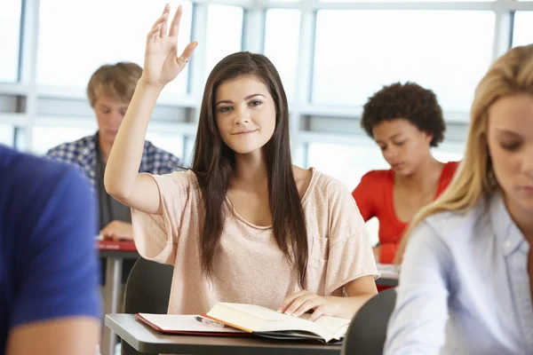 Menina adolescente com a mão para cima na classe — Fotografia de Stock