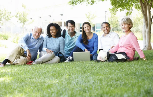 Étudiants adultes utilisant un ordinateur portable dans le parc — Photo