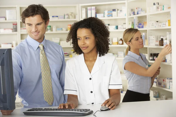 Pharmacists working on computer in pharmacy — Stock Photo, Image