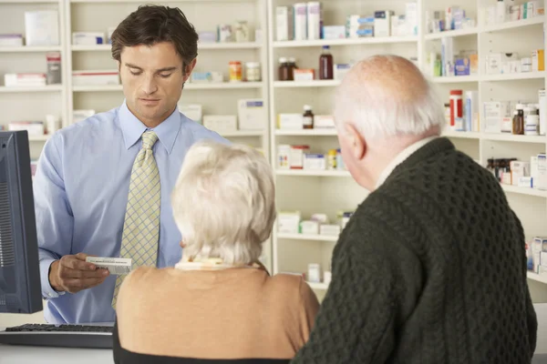 Farmacista con coppia anziana in farmacia — Foto Stock