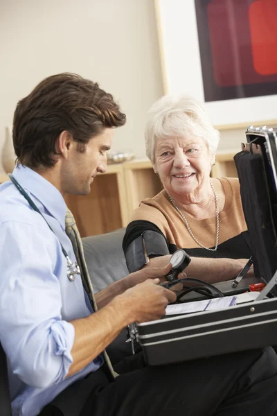 Médico tomando la presión arterial de la mujer —  Fotos de Stock