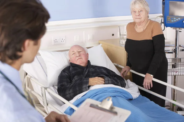 Врач разговаривает со старшей парой в больнице — стоковое фото