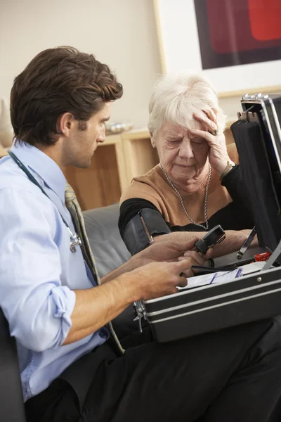 Médico tomando la presión arterial de la mujer — Foto de Stock