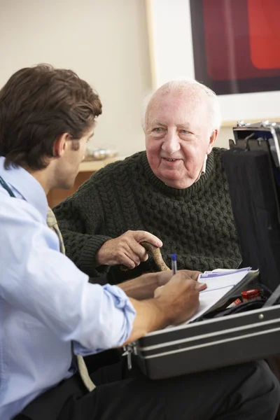 Doctor visitando a un hombre mayor en casa — Foto de Stock