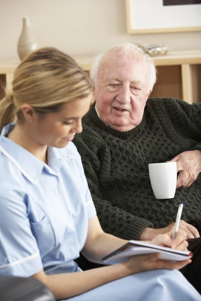 Nurse visiting senior man at home — Stockfoto