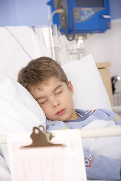 Young boy asleep in hospital bed — Stockfoto